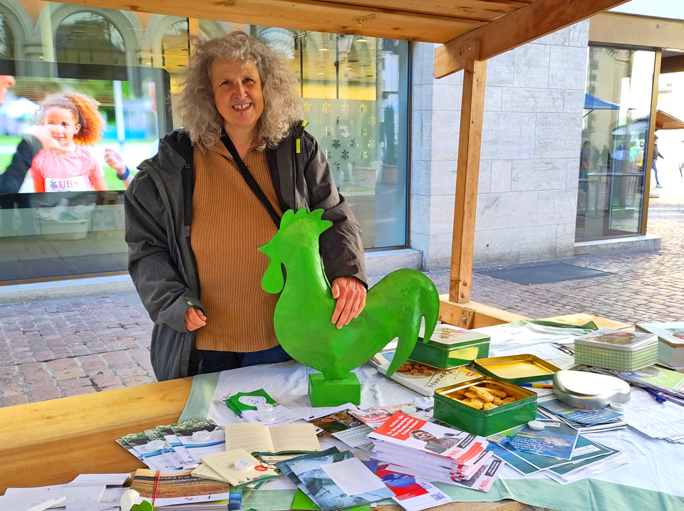 Gaby Zimmermann präsentiert an einem Stand das kirchliche Umweltmanagement Grüner Güggel
