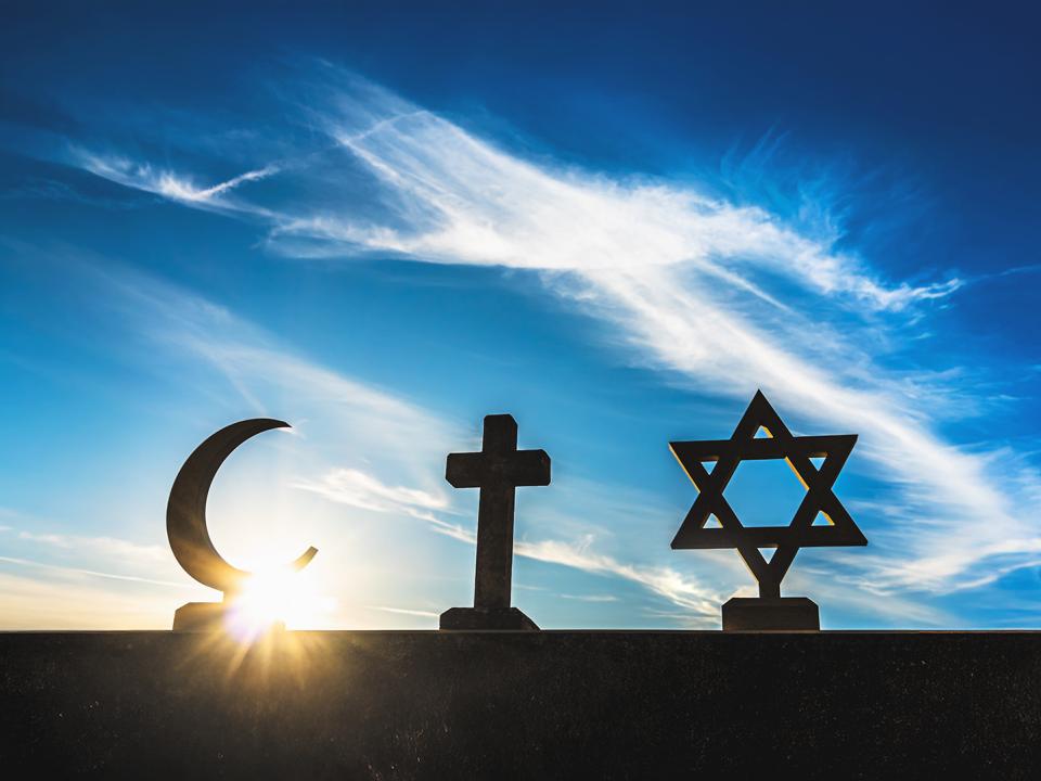 Symbolbild: muslimische Sichel, christliches Kreuz und Judenstern gegen Himmel