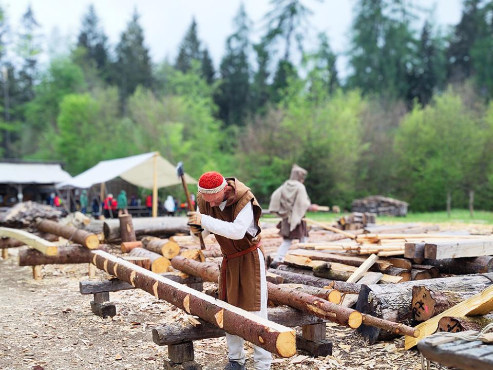 Nur mit einfachen Werkzeugen und Muskelkraft werden Baumstämme fürs Bauen vorbereitet.