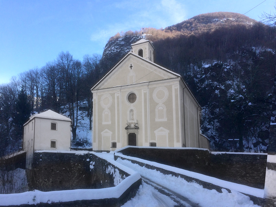 Die St.-Anna-Kirche mit Steinbogenbrücke und ehemaligem Pilgerhospiz in Roveredo (GR).