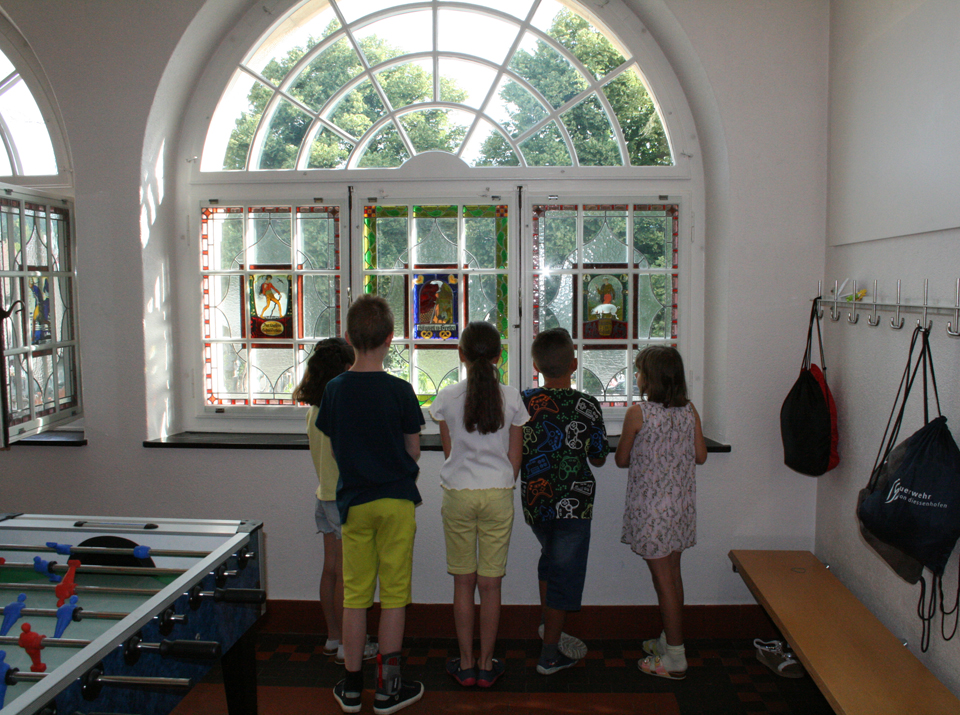 Zweitklässler vor den Märchen-Glasfenstern 