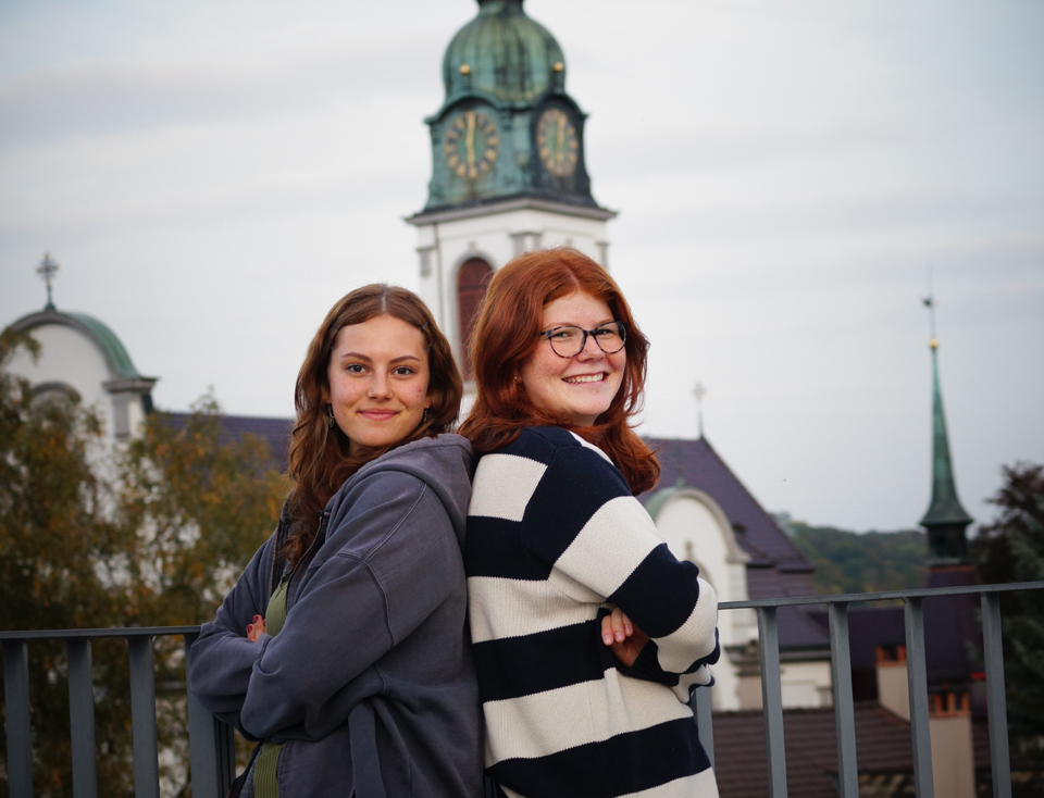 Linn (l.) und Ladina vor dem Kirchturm ihrer Pfarrei