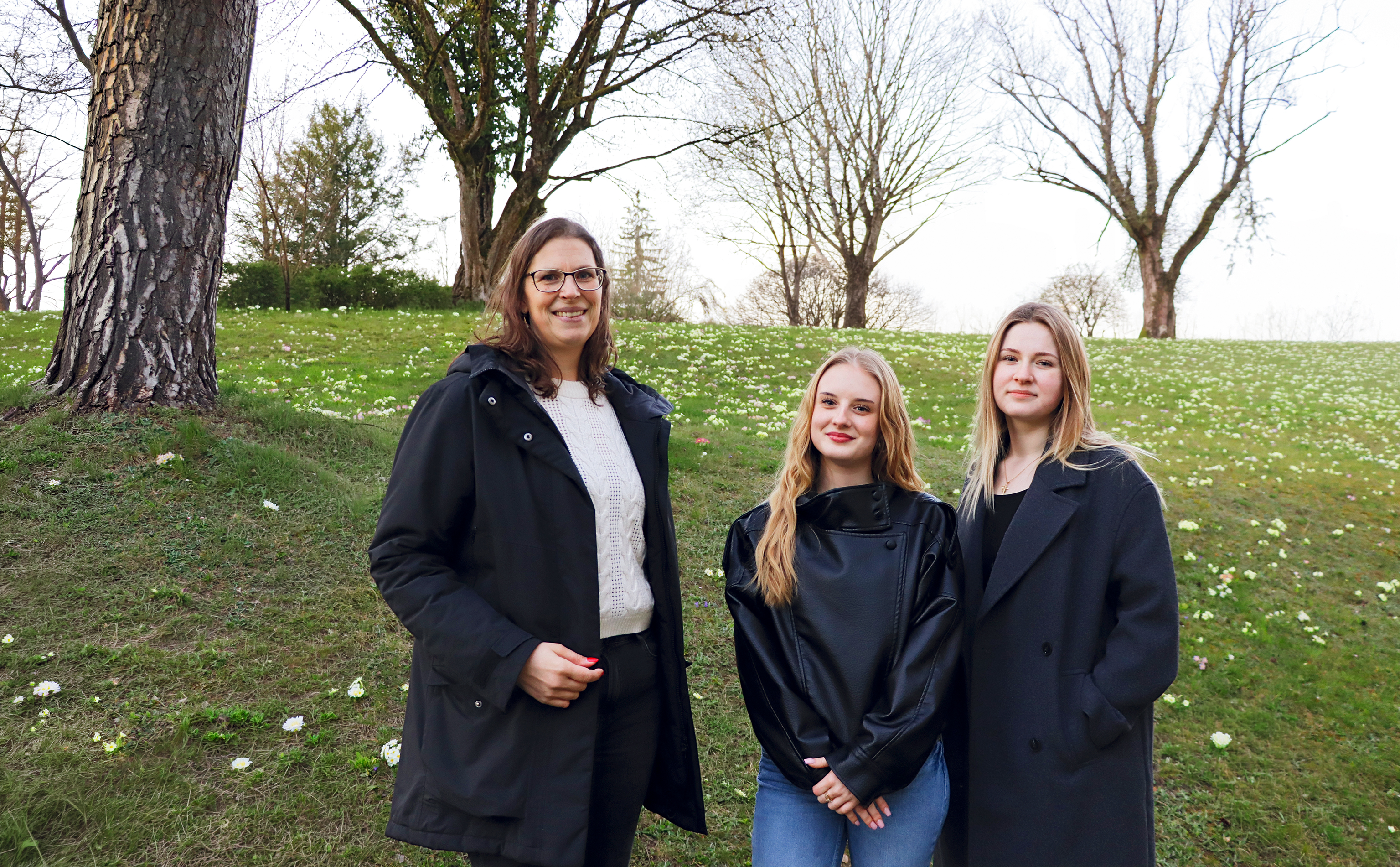 Regina Wettstein, Jamie Gulic und Helena Mršic stehen in Frühlingswiese