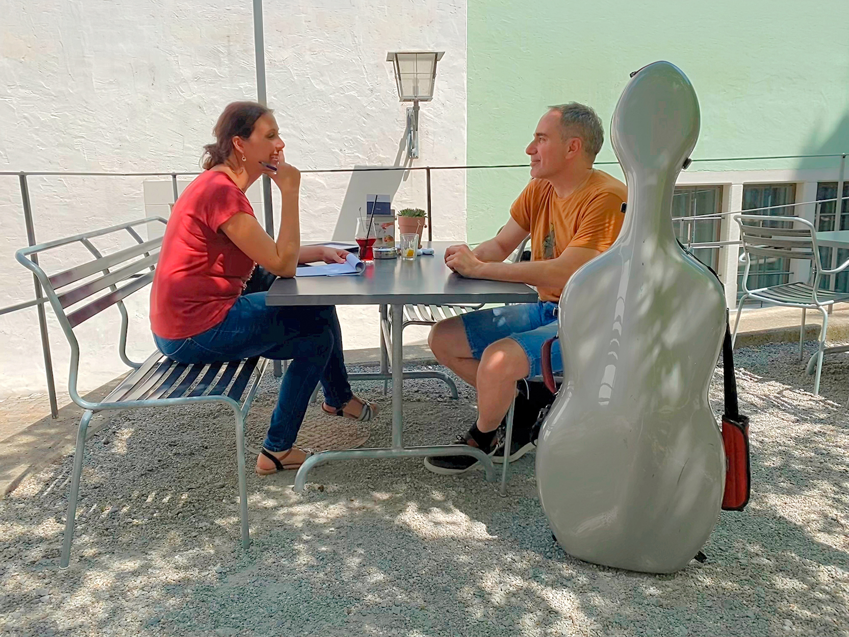 Redaktorin Ramona Nock vom Pfarreiblatt Zug im Gespräch mit Proficellist Jonas Iten in einer Gartenwirtschaft