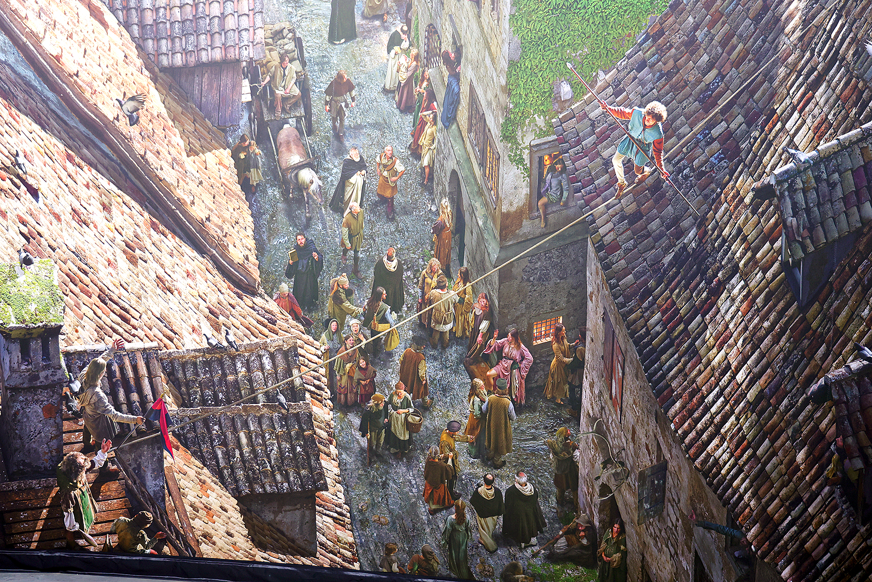 Ein Seiltänzer über einer Gasse in Konstanz während des Konzils, darunter Zuschauer